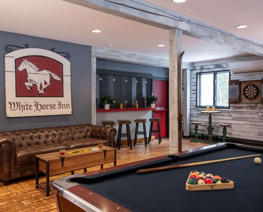A pool table and sofa in the game room at White Horse Lodge in Vermont