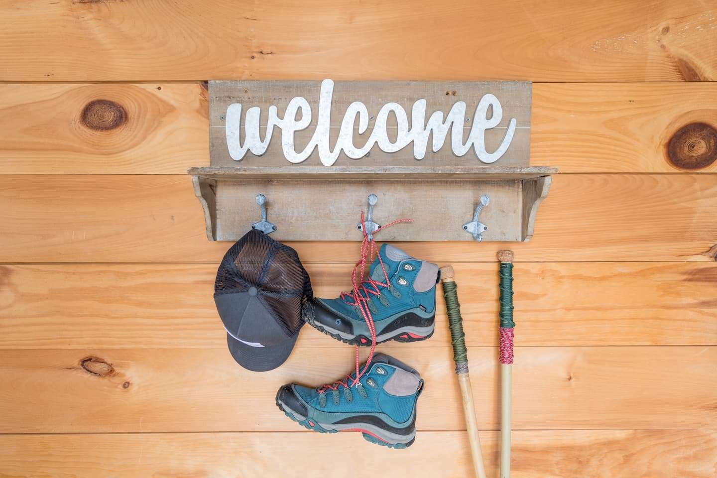 Hiking boots, a hat, and a walking stick hanging on a shelf at our Vermont lodging