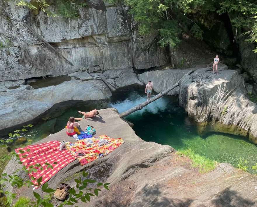 A group of people spread out at Warren Falls for the day